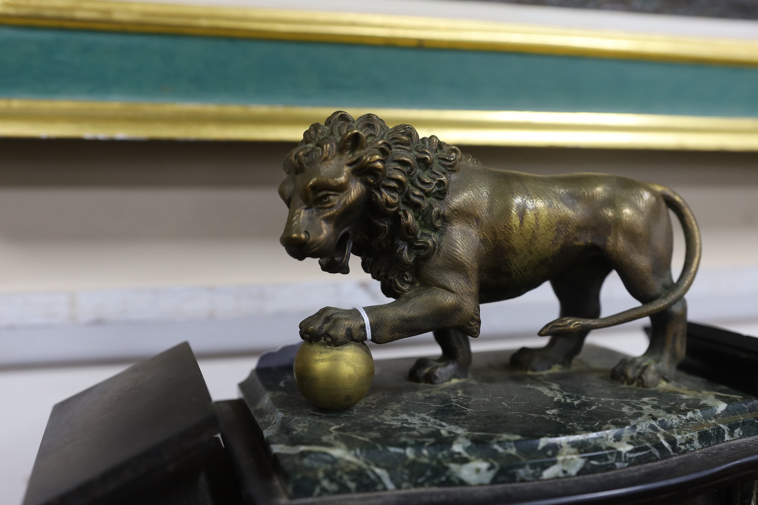 An early 20th century black slate clock garniture with metal lion mount, clock 37cm high